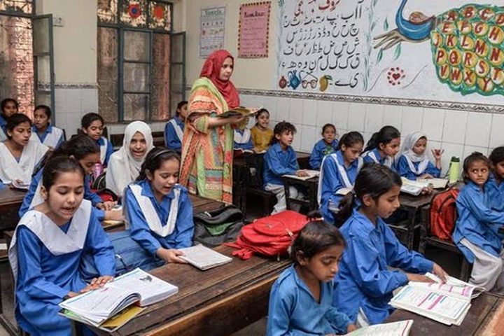 Students and their teacher in a girls' school classroom in District Okara